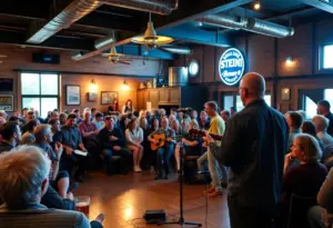 A performer on stage at a brewery with an audience enjoying the live music